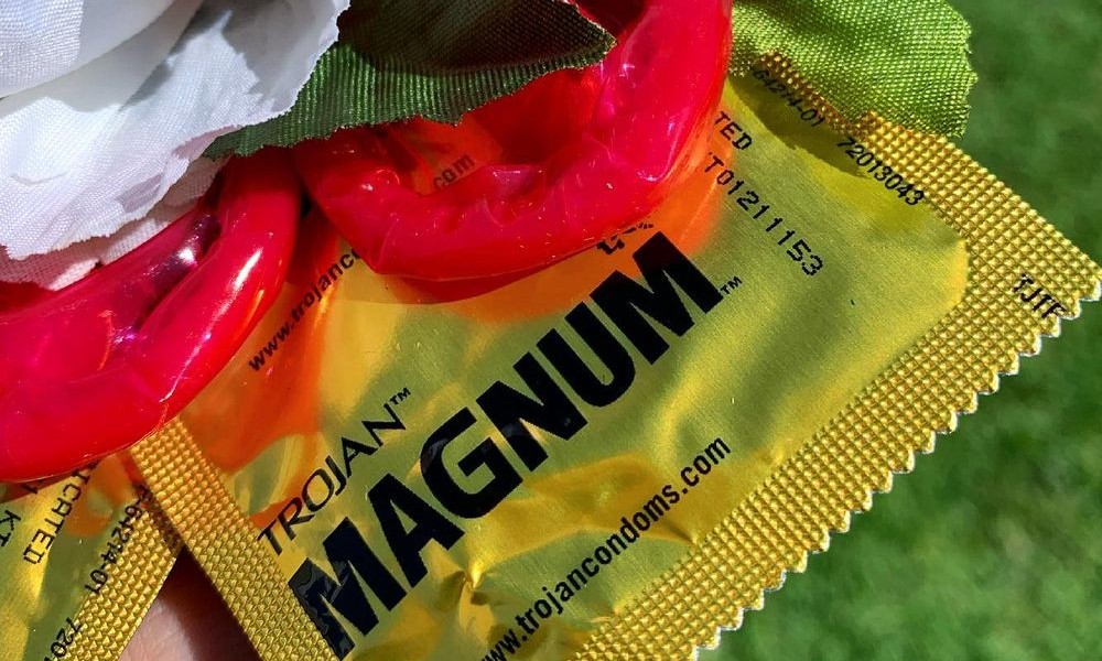 Magnum condom in a hand with a flower